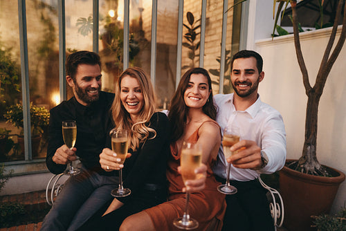Smiling friends celebrating with sparkling wine