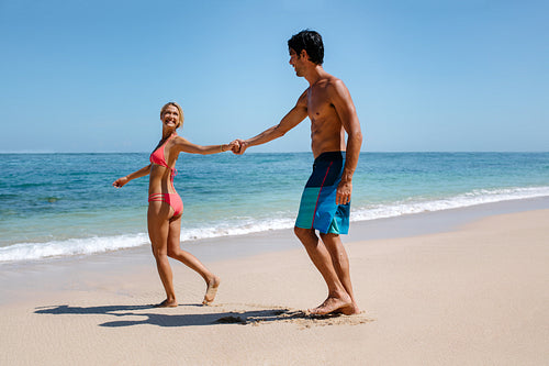 Romantic couple walking on beautiful tropical beach
