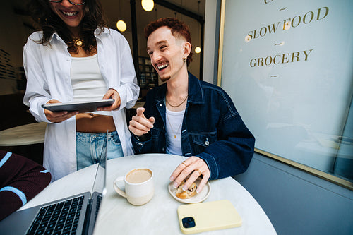Young business people collaborating together in a cafe