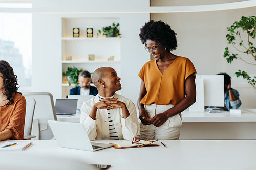 Two successful businesswomen collaborating in a creative office