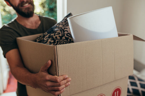 Man carrying household stuff in a packing box