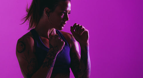 Close up portrait of fit woman on purple background