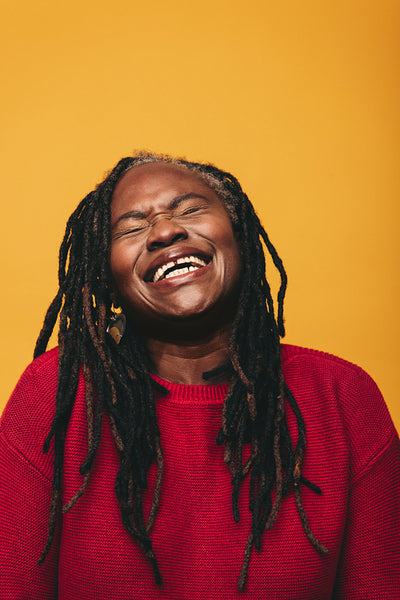 Happy black woman laughing cheerfully in a studio