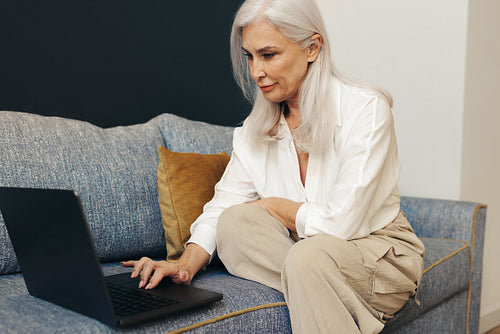 Senior woman using a laptop for freelance work at home