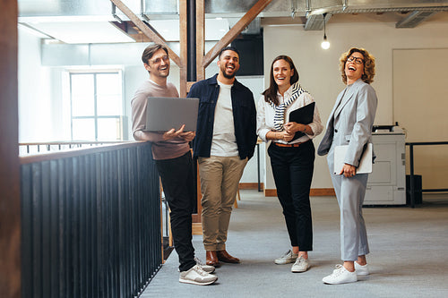Successful business team laughing while standing together
