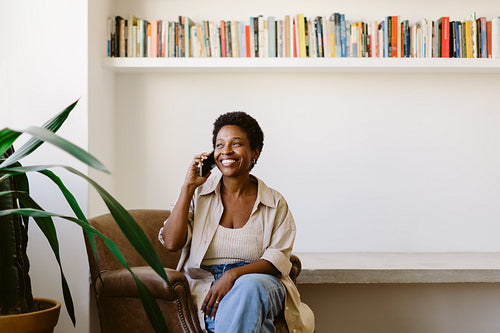 Happy mature woman engaged in a phone call on the sofa in her living room