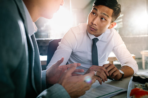 Business men discussing over a project in restaurant