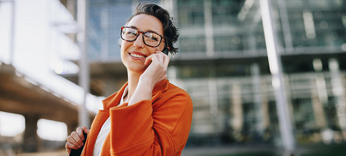 Happy businesswoman making a phone call during her morning commute in the city