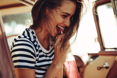 Smiling woman having soft drink in car