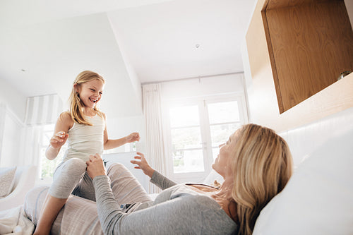 Mother and daughter playing in bedroom