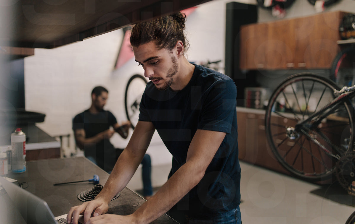 Mechanic working on laptop in bicycle workshop – Jacob Lund Photography ...