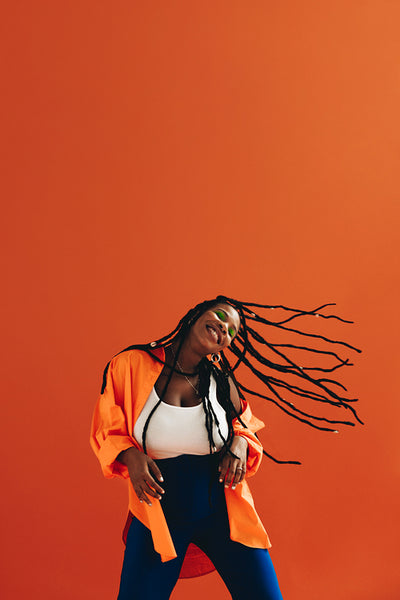 Happy young woman dancing and flipping her hair in a studio