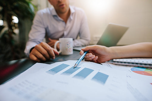 Business people discussing financial statistics in office