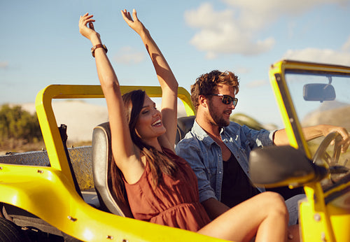 Cheerful young couple enjoying road trip