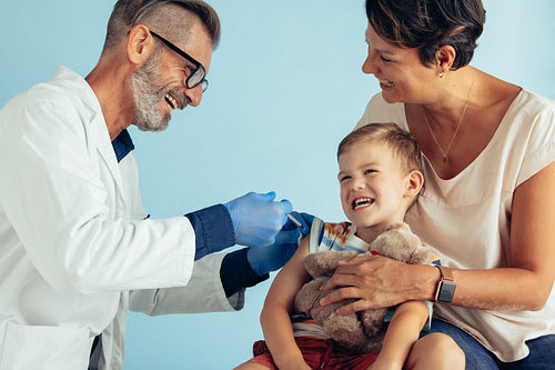 Smiling boy getting vaccine from a pediatrician