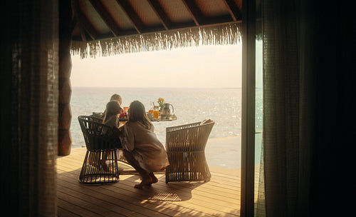 Mother and daughter enjoying a tropical seaside vacation at an overwater bungalow