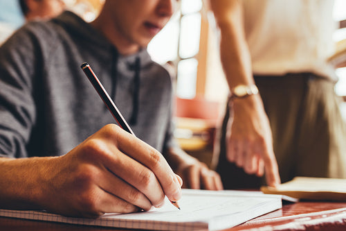 Young student writing in a notebook in classroom