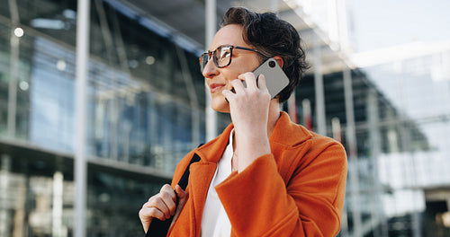 Mature businesswoman speaking on the phone while commuting to work in the city