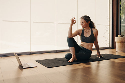 Cheerful senior woman doing an ok gesture during a yoga class