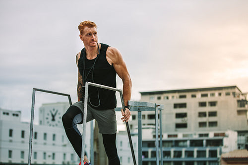 Fitness man climbing rooftop stairs