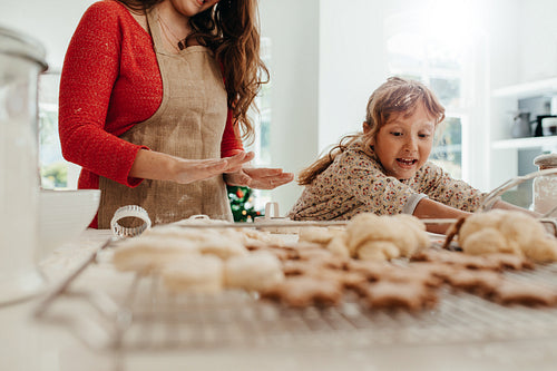 Mother teaching daughter to make cookies for Christmas.