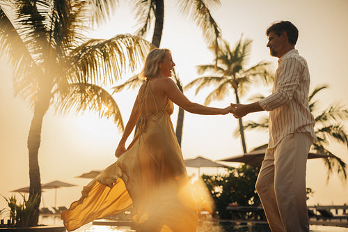 Romantic moment. Couple holding hands and dancing by the beach
