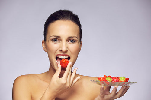 Beautiful young caucasian woman eating healthy fruits