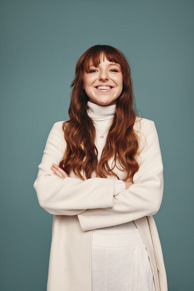 Cross-armed woman smiling cheerfully in a studio