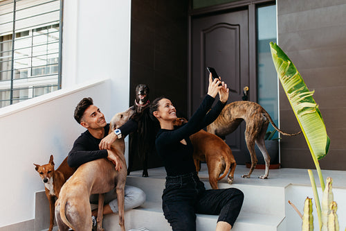 Couple taking a selfie with all their dogs