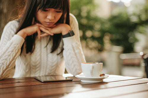 Young woman using digital tablet at a cafe