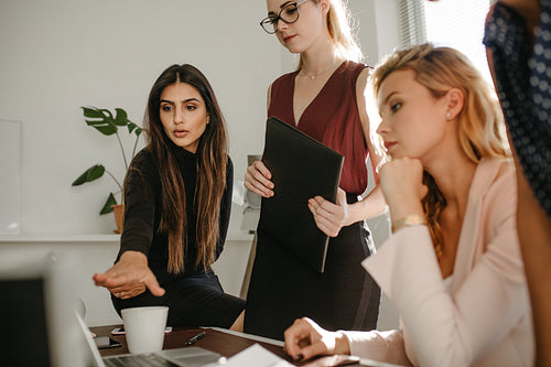 Group of women discussing together with a laptop
