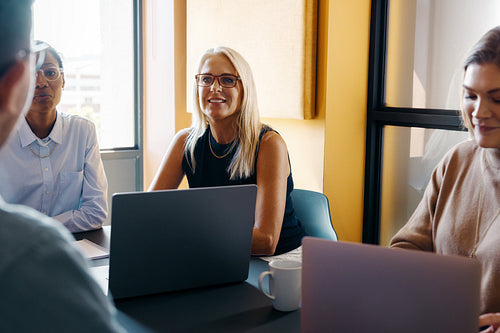 Professional women collaborating in an office setting during a team meeting