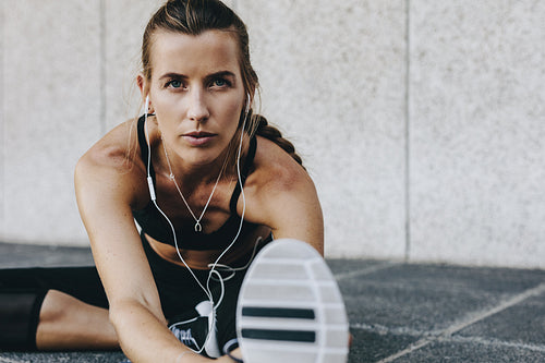 Woman athlete warming up doing stretching exercises outdoors