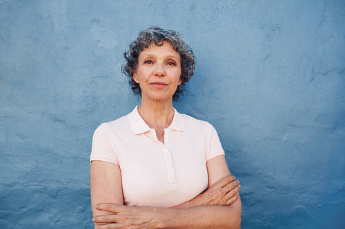 Confident mature woman standing with her arms crossed 