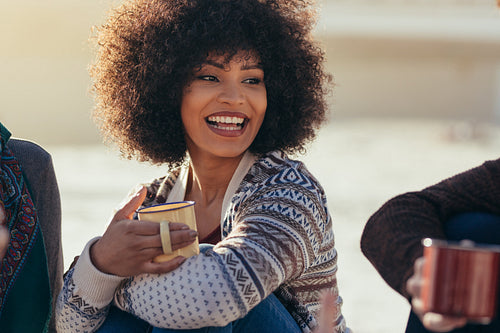 Woman having coffee with friends at the beach