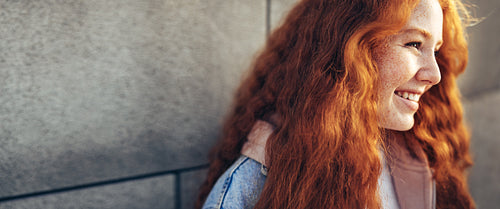 Smiling girl standing against the wall
