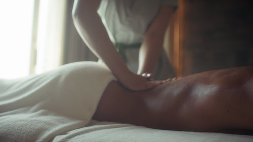 Relaxing back massage for a woman in a tranquil spa environment promoting wellness