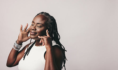 Mature woman enjoying her favourite music using earbuds