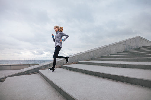 Healthy sports woman running down the stairs