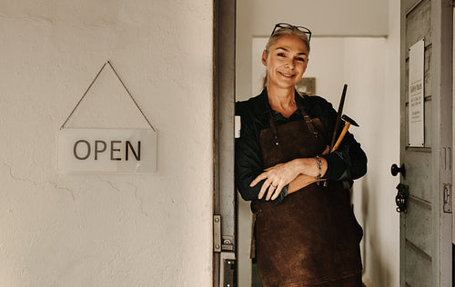 Senior jeweler at workshop door