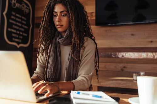 Freelancer woman working on laptop computer in a cafe