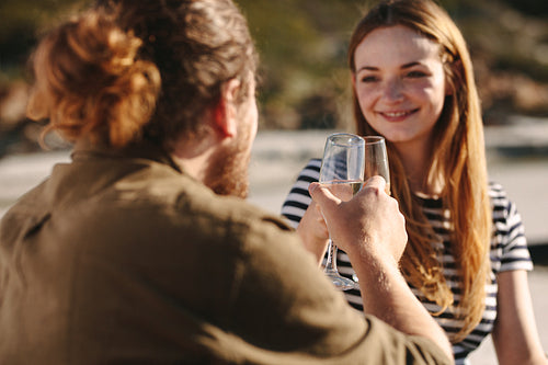 Couple in love toasting champagne glasses at the beach