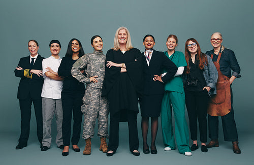 Happy female workers smiling at the camera in a studio