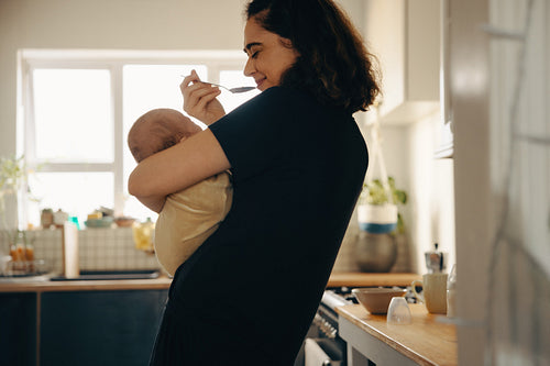Mother holding baby and eating