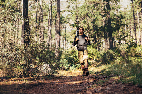 Man walking in forest wearing a backpack