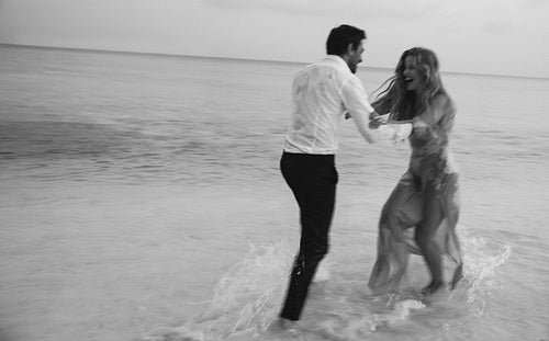 Romantic bride and groom playing on wedding day at the beach