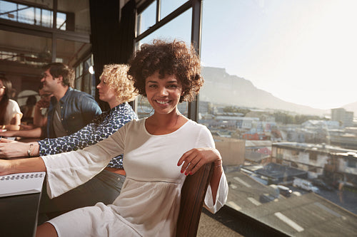 Happy young african woman sitting at a meeting in office