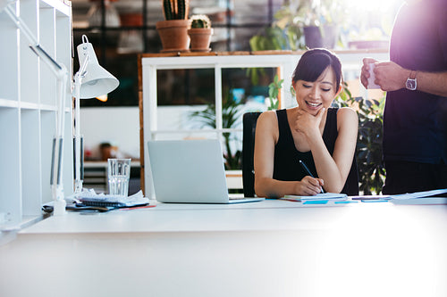 Businesswoman working with colleague standing by