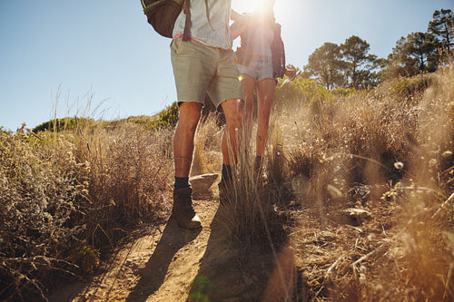 Man and woman hikers walking on dirt trail