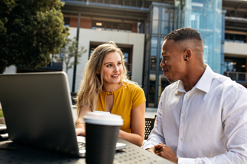 Business colleagues talking while sitting at office cafeteria